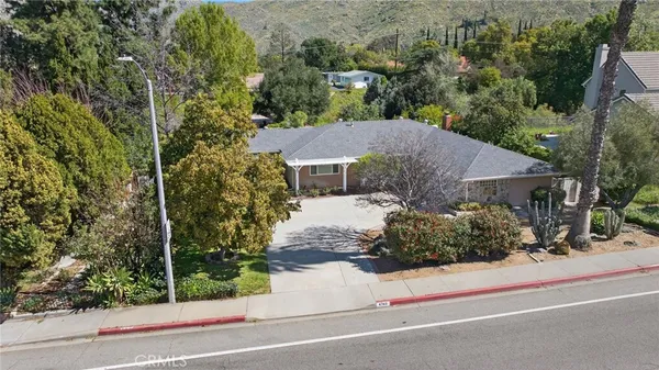 an aerial view of a house with a yard and large trees