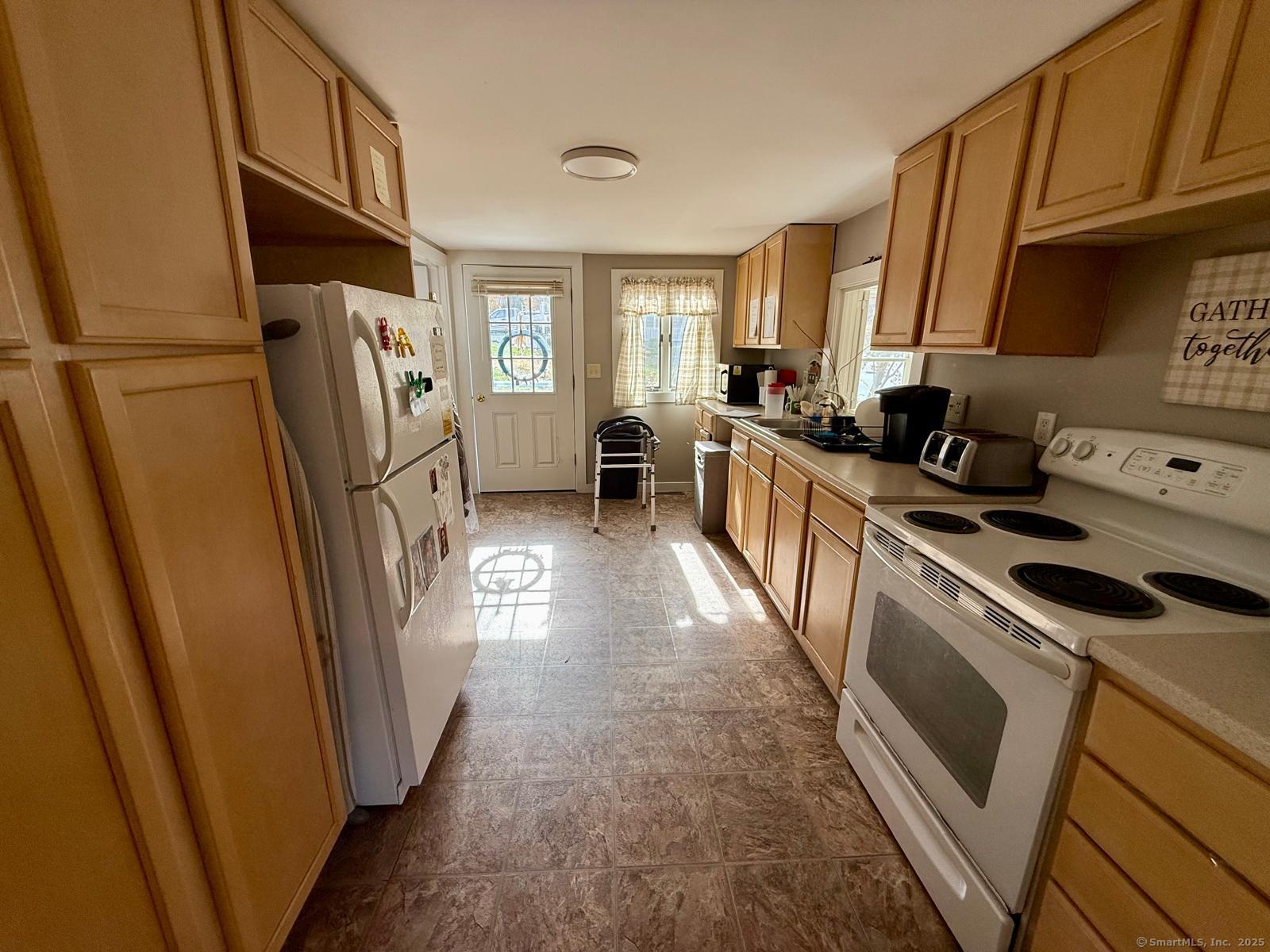 21 Boughton Road Old Lyme, CT 06371 - Photo 6 of 21 a kitchen with stainless steel appliances a refrigerator a sink a stove a washer dryer and cabinets