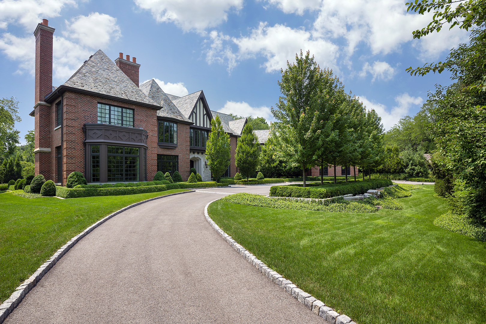 37 Woodley Road Winnetka, IL 60093 - Photo 7 of 66 a view of a big yard in front of a brick house with a big yard and large trees