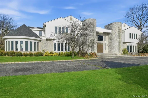 a view of a big house with a big yard and large trees