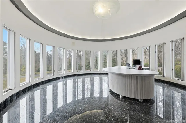 a living room with a large window and kitchen view