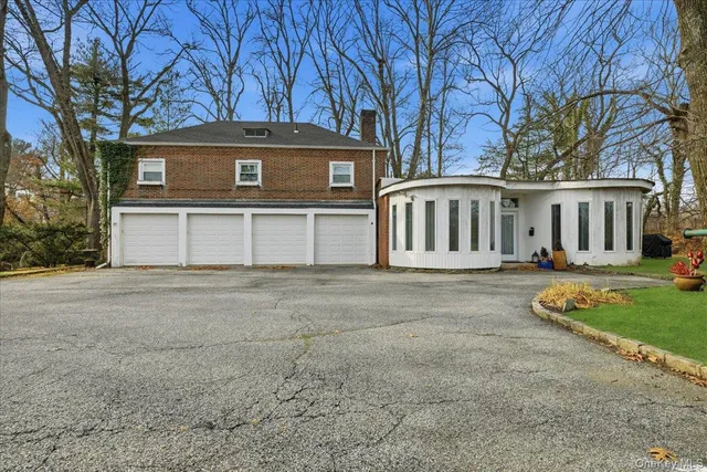a front view of a house with a garden and trees