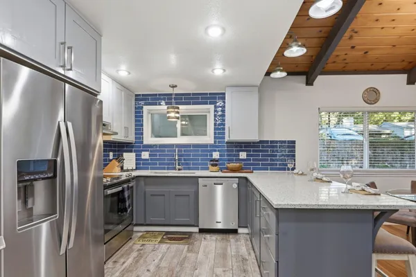 a kitchen with refrigerator and chairs