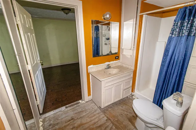 a bathroom with a sink a toilet a mirror and shower