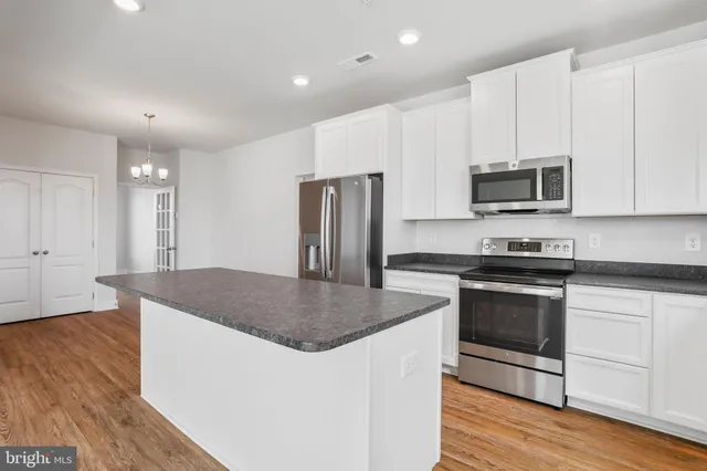 a living room with furniture kitchen view and a large window