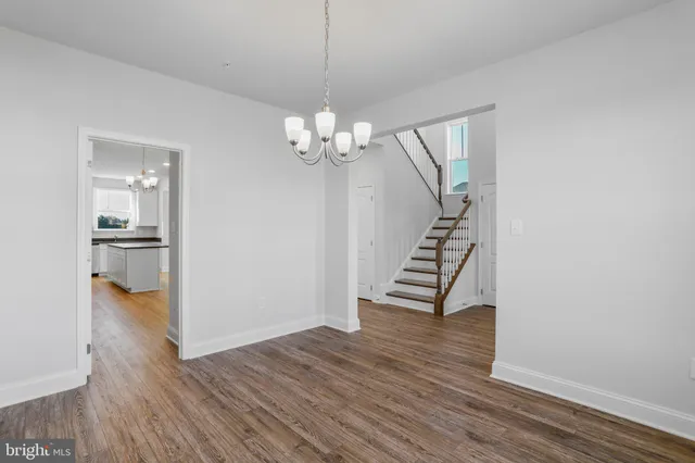 a view of empty room with wooden floor and window