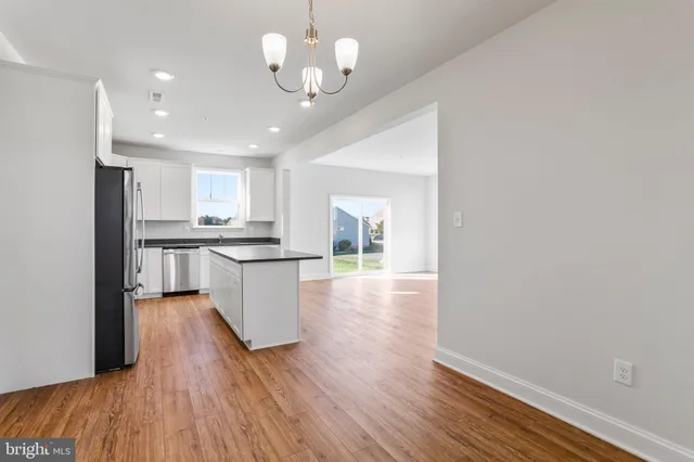 a kitchen with granite countertop a counter space and wooden floor