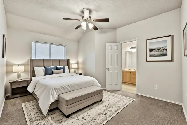 a bedroom with a large bed and a chandelier