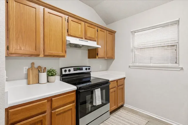 a kitchen with stainless steel appliances a stove a sink and cabinets