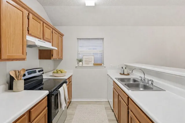 a kitchen that has a sink a stove and a table