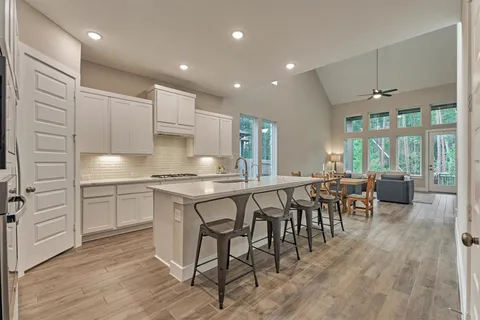 a kitchen with stainless steel appliances granite countertop a table chairs sink and cabinets