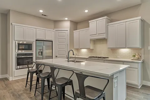 a kitchen with a table chairs stove and cabinets