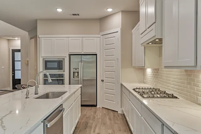 a kitchen with a sink stove and refrigerator