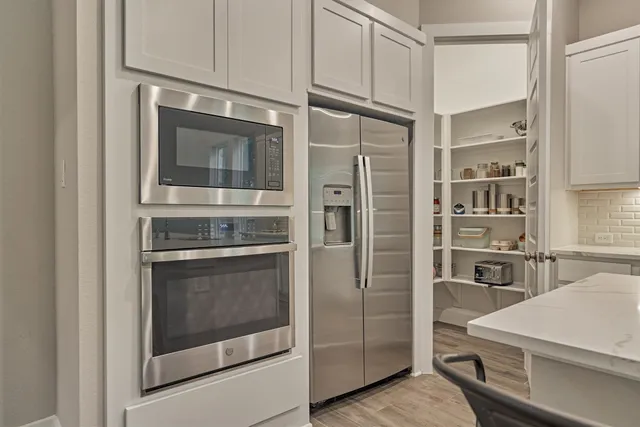 a kitchen with stainless steel appliances granite countertop a refrigerator and a stove
