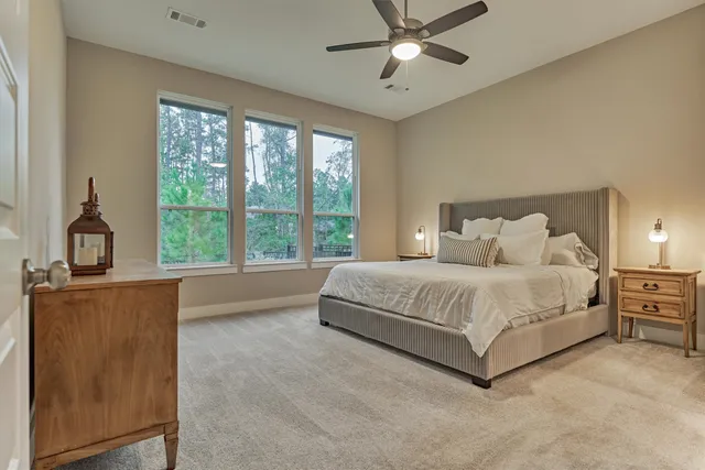 a spacious bedroom with a large bed and a chandelier