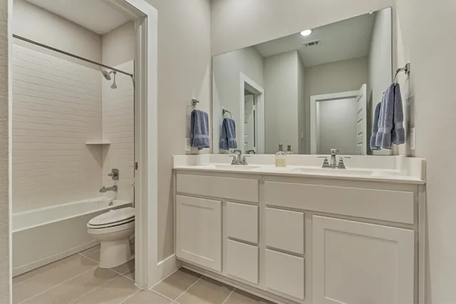 a bathroom with a double vanity sink toilet mirror and shower