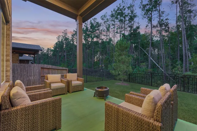 a patio with patio a couch and wooden fence