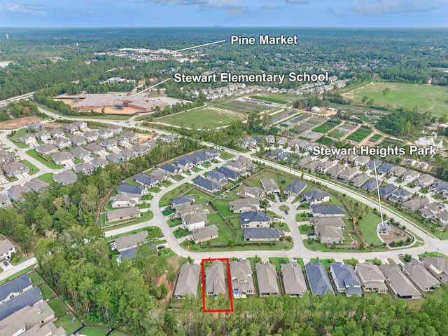 an aerial view of residential houses with outdoor space and trees