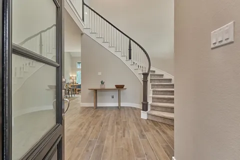 a view of entryway and hall with wooden floor