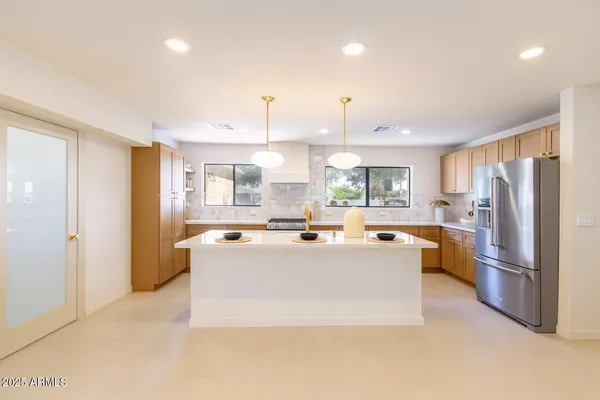 a view of a kitchen with stainless steel appliances granite countertop a refrigerator and a refrigerator
