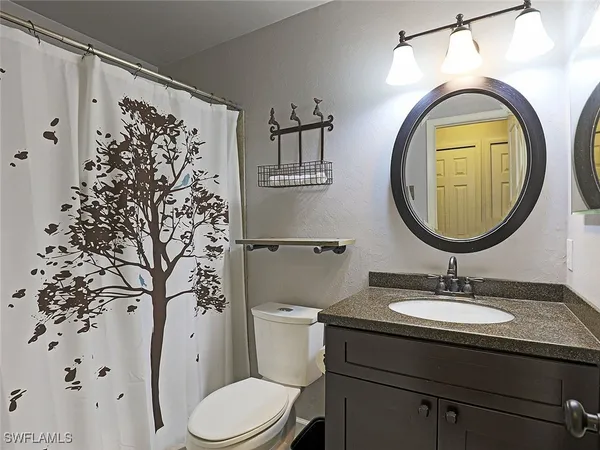 a bathroom with a toilet a sink and a mirror