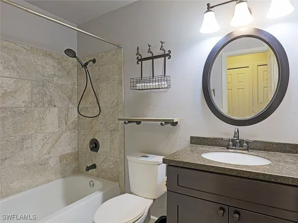 a bathroom with a sink a mirror a toilet and a bathtub