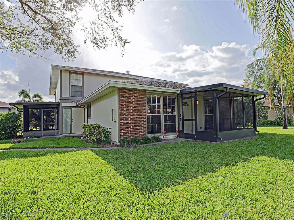 5804 Newfoundland Fort, Unit 1 Fort Myers, FL 33907 - Photo 2 of 29 a view of a house next to a big yard and large trees