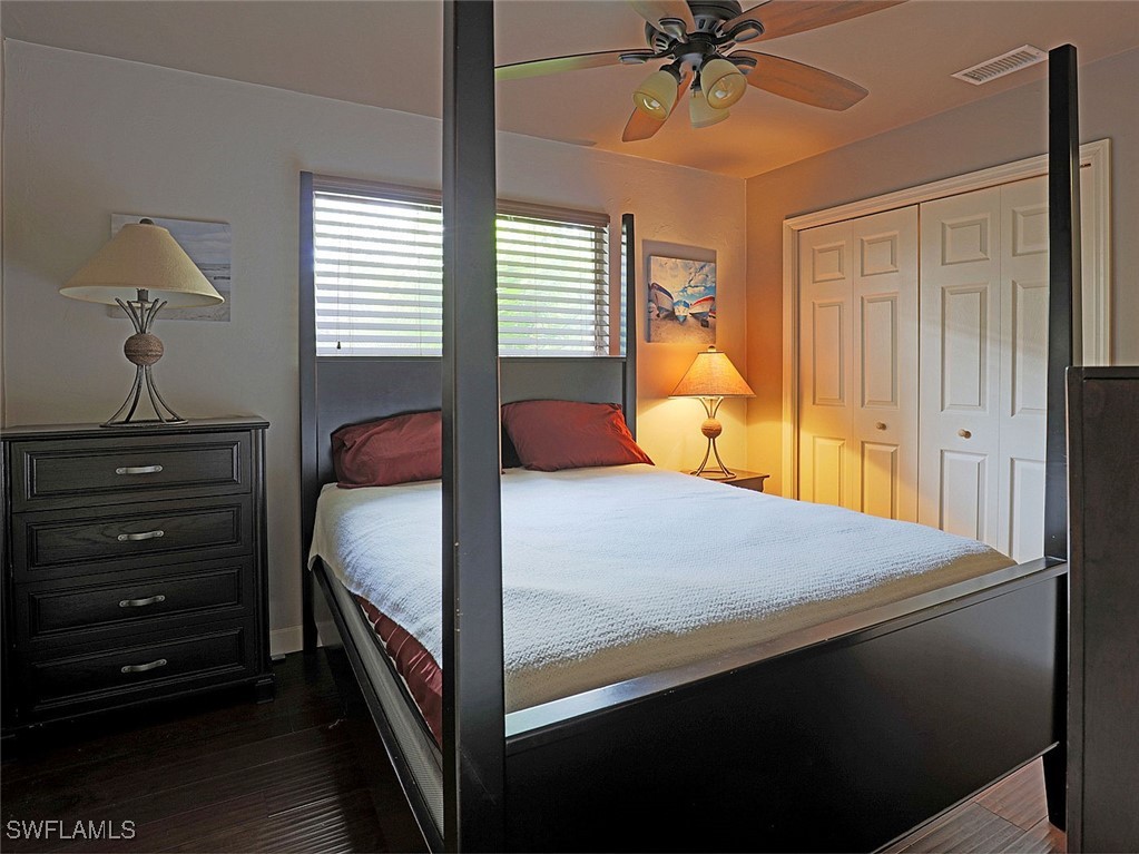 5804 Newfoundland Fort, Unit 1 Fort Myers, FL 33907 - Photo 23 of 29 a bedroom with a bed and a chandelier
