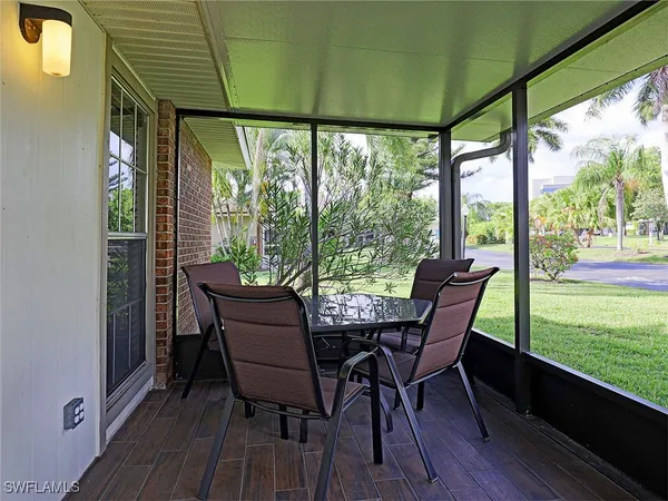 a view of a porch with furniture and wooden floor