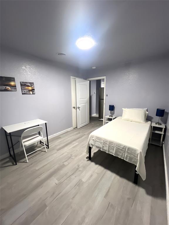 2136 Ridgeway Street Arlington, TX 76010 - Photo 19 of 32 a spacious bedroom with a bed a table and chair