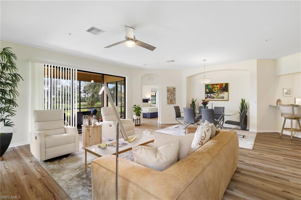 3787 Costa Maya Way, Unit 101 Estero, FL 33928 - Photo 11 of 49 Living room featuring light wood-style floors, a ceiling fan, and arched walkways