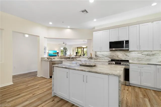 a kitchen with stainless steel appliances granite countertop a stove a sink and a microwave