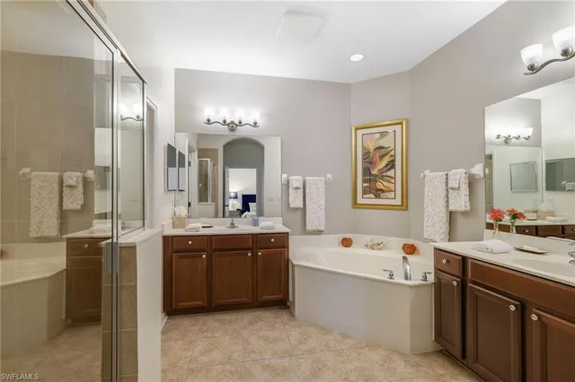a large bathroom with a double vanity sink mirror and bathtub