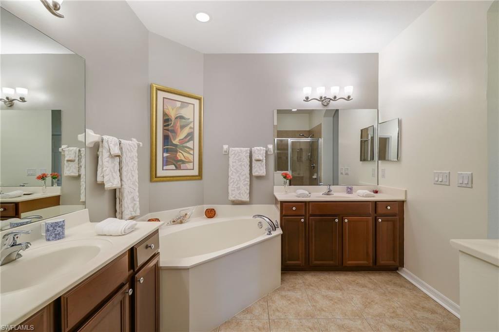 3787 Costa Maya Way, Unit 101 Estero, FL 33928 - Photo 24 of 49 Bathroom featuring a bath, light tile patterned floors, a stall shower, and two vanities
