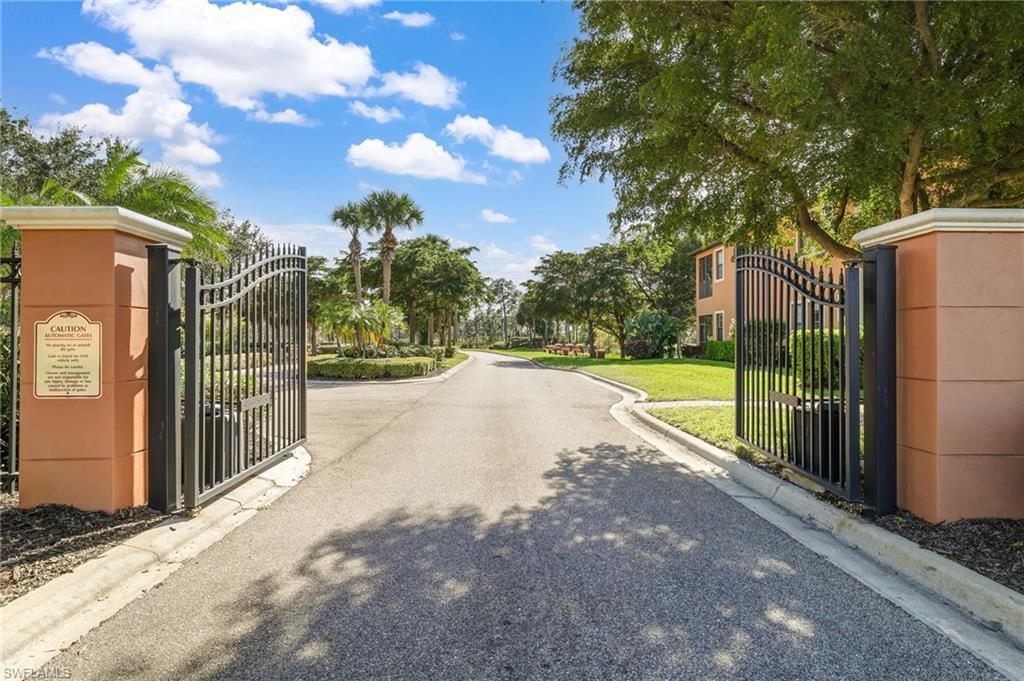 3787 Costa Maya Way, Unit 101 Estero, FL 33928 - Photo 35 of 49 View of asphalt street featuring a gate, curbs, and a gated entry
