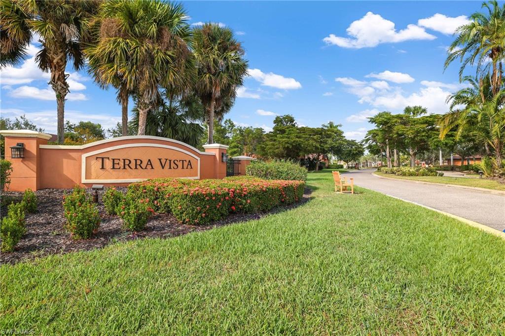3787 Costa Maya Way, Unit 101 Estero, FL 33928 - Photo 37 of 49 Community sign featuring a lawn