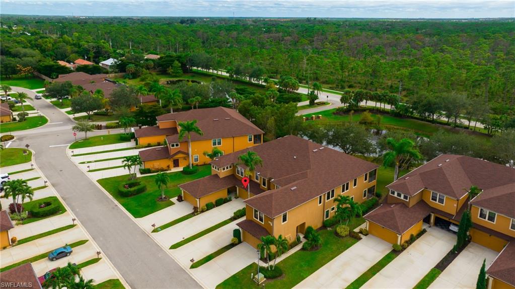 3787 Costa Maya Way, Unit 101 Estero, FL 33928 - Photo 41 of 49 Aerial view of residential area featuring a forest