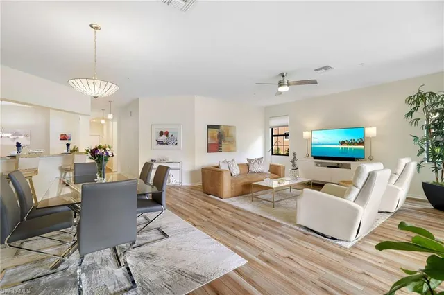 a living room with furniture a flat screen tv and kitchen view