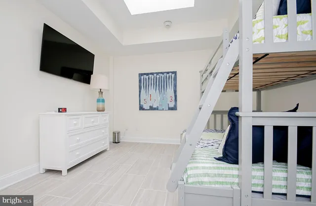 a view of a hallway with wooden floor and a bathroom