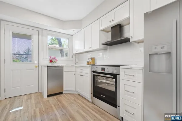 a kitchen with stainless steel appliances a stove microwave and refrigerator
