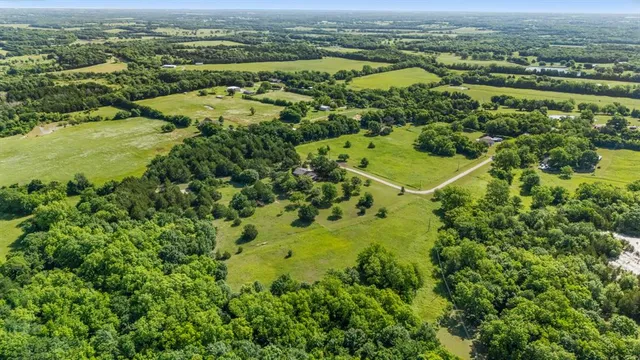 an aerial view of ocean with residential houses with outdoor space and trees