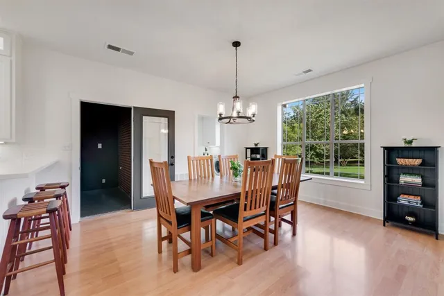 a dining room with furniture window entryway and wooden floor