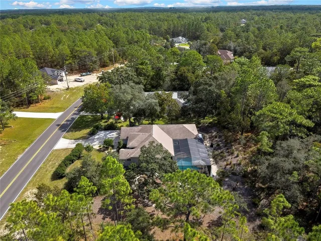 a aerial view of residential houses with outdoor space and trees