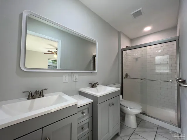 a bathroom with a toilet sink vanity and mirror