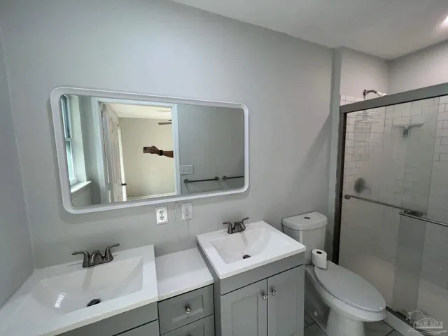 a bathroom with a toilet a sink a mirror a bathtub and vanity