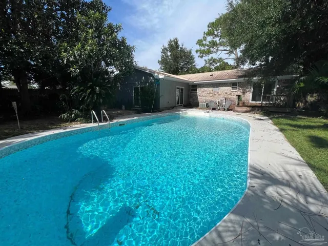 a front view of a house with a garden and trees