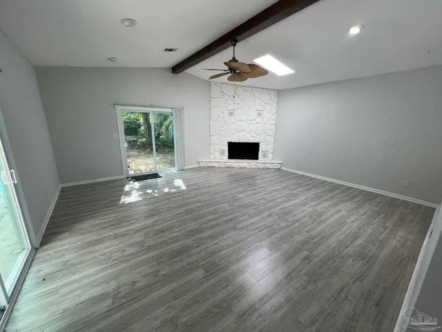 an empty room with wooden floor and fireplace