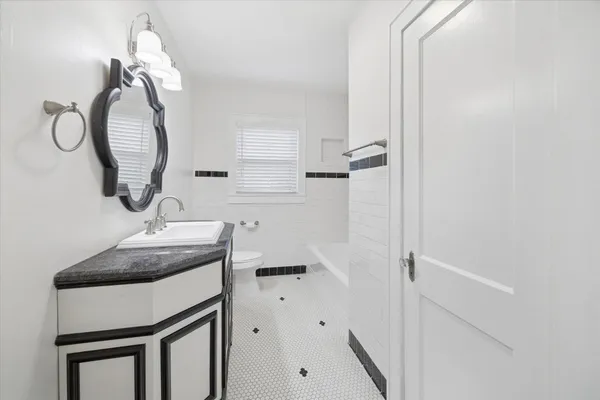 a bathroom with a sink a toilet and a mirror