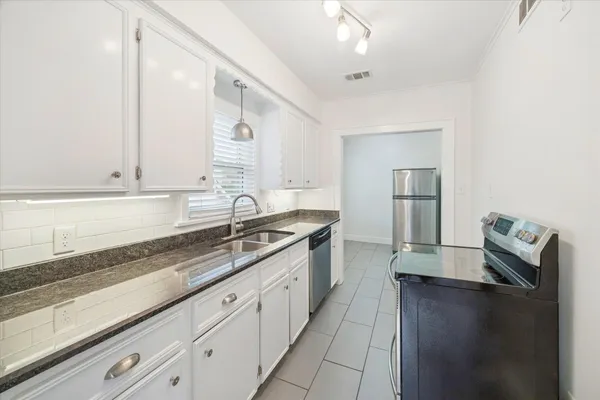 a large kitchen with granite countertop a sink and dishwasher stove top oven