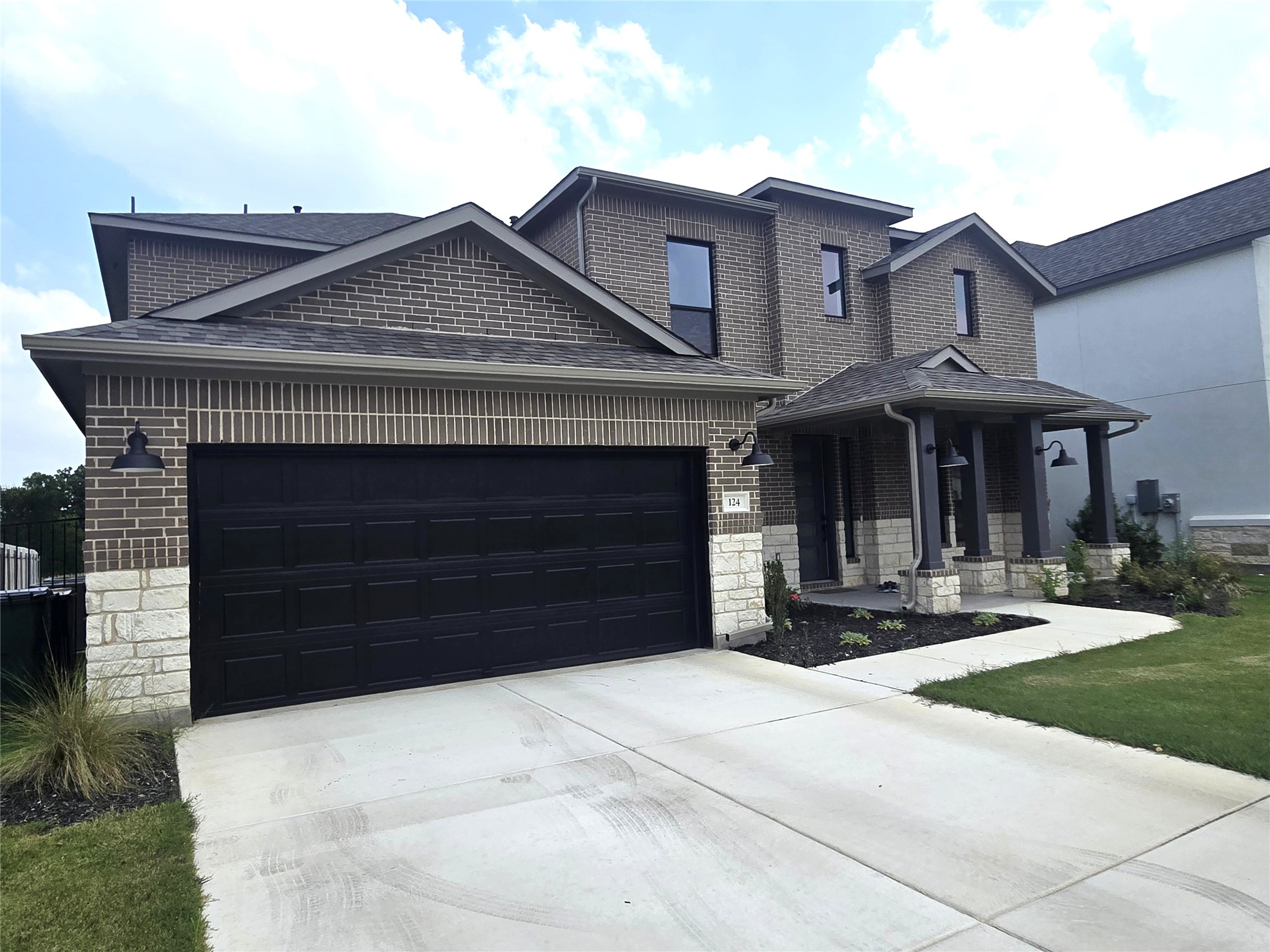 124 Ribera Drive Liberty Hill, TX 78642 - Photo 3 of 40 This newly constructed residence showcases a contemporary brick and stone facade with an inviting covered entry.